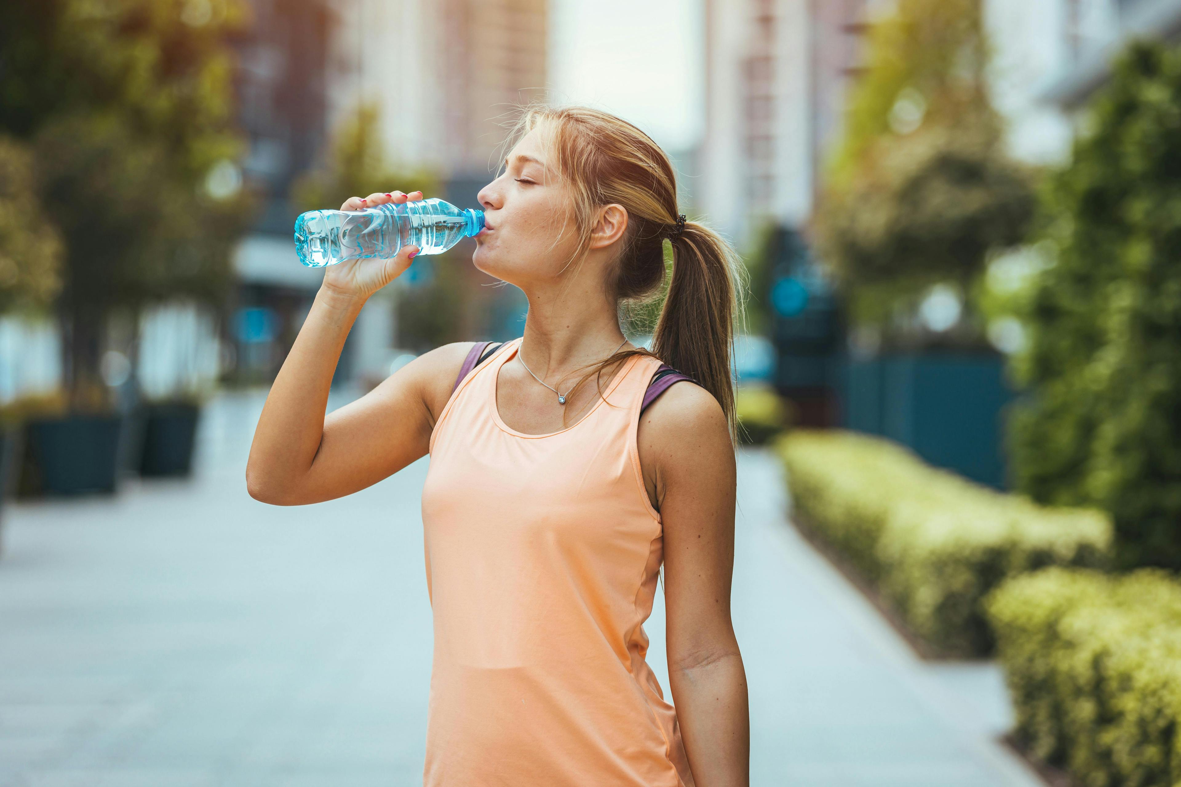 Woman Drinks Water from Plastic Bottle
